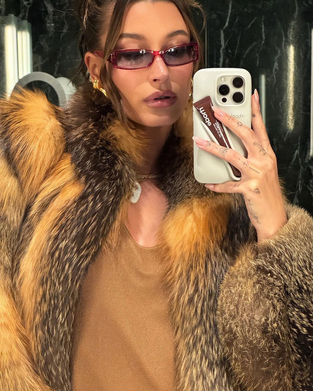 hailey bieber tager billede i spejlet, mens hun har solbriller på